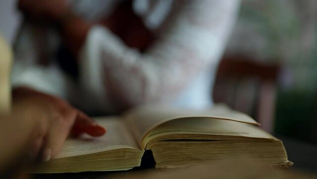 closeup view of old book with poems and love novels, woman flipping pages, vintage and retro style