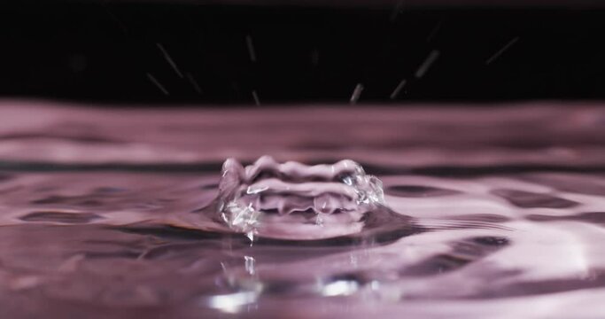 Video of close up of drops of water with copy space on pink background