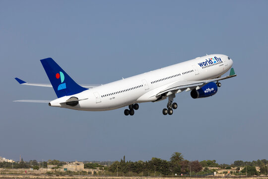 Luqa, Malta - July 21, 2023: World 2 Fly Airbus A330-343 (Reg.: CS-TRH) departing Malta after having been painted in this airline's color scheme, arrived in yellow paint on June 23rd.