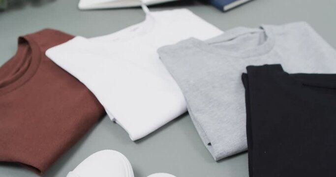 Video of flat lay of t shirts with copy space on grey background