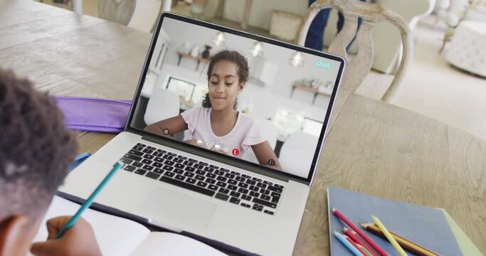 Composition of african american boy on laptop online learning with biracial schoolgirl