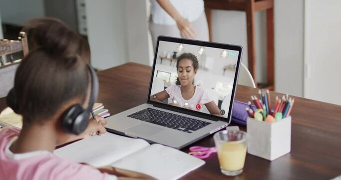 Composition of african american schoolgirl on laptop online learning with biracial schoolgirl