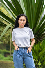 Expertly arranged for mockup purposes, the image features a woman donning a blank white shirt, effortlessly posing with grace