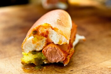 Savory Delight: Close-Up of a Delicious Hot Dog Served on a Wooden Platter, Satisfying Your Appetite in 4K Resolution