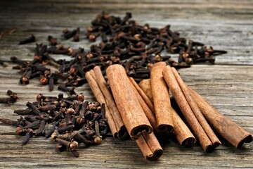 Aromatic Delights: Close-Up of Cinnamon Sticks, Whole Clove, and Raw Sugar Arranged on a Rustic Wooden Table, Captured in 4K Resolution