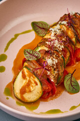 Vegetable ratatouille in a plate on a dark background.