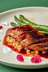 Baked duck breast with cherry sauce and asparagus in a plate