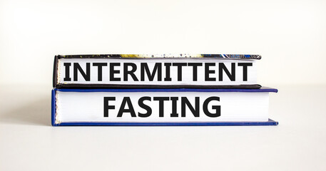 Intermittent fasting symbol. Concept words Intermittent fasting on beautiful books. Beautiful white table white background. Healthy lifestyle intermittent fasting concept. Copy space.