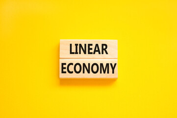 Linear economy symbol. Concept words Linear economy on beautiful wooden block. Beautiful yellow table yellow background. Business linear economy concept. Copy space.