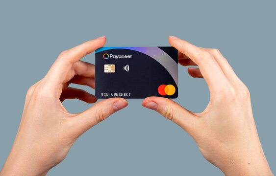Payoneer, plastic bank card in hands.