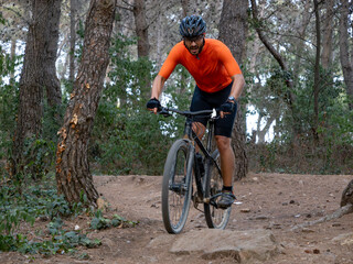 Fototapeta na wymiar Man riding mtb mountain bike through forest. Mountain bike trail, extreme sport activities