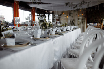 Wedding decor, table setting with white dishes, on the background of lanterns