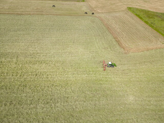 Obraz premium Heu wird mit dem Traktor zum trocknen gewendet