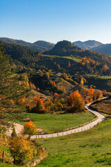 Autumn landscape with road and country houses in mountains