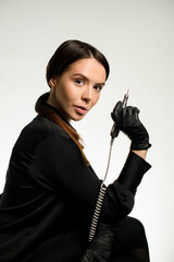 Portrait of brunette woman manicurist in black uniform with electric machine to remove nail polish