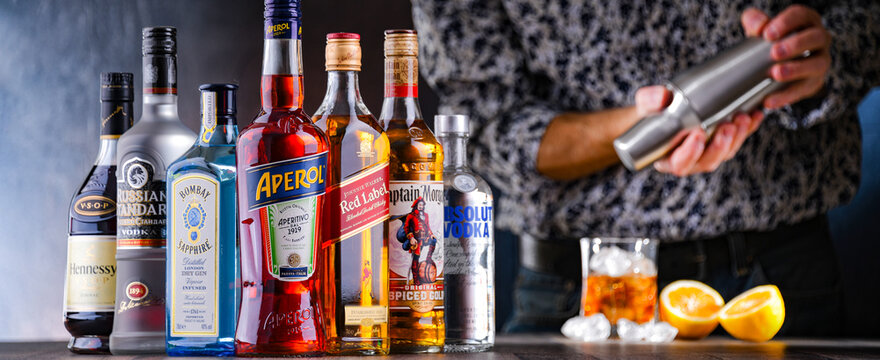 Bottles of assorted alcoholic beverages and bartender