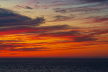Naklejka na ściany i meble Panoramic view of the ocean sunset against the background of multi-colored stratus clouds. Natural background for abstract reflection, relaxation, blank for designers, visual images, unique moments