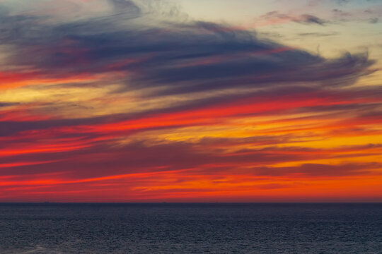 Panoramic view of the ocean sunset against the background of multi-colored stratus clouds. Natural background for abstract reflection, relaxation, blank for designers, visual images, unique moments