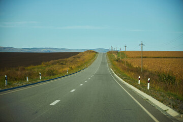 Fototapeta na wymiar Country highway in the autumn. Empty roads among the hills