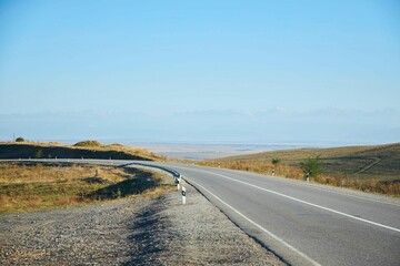 Country highway in the autumn. Empty roads among the hills