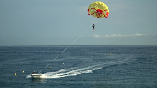 girl on a parachute attached to a motorboat