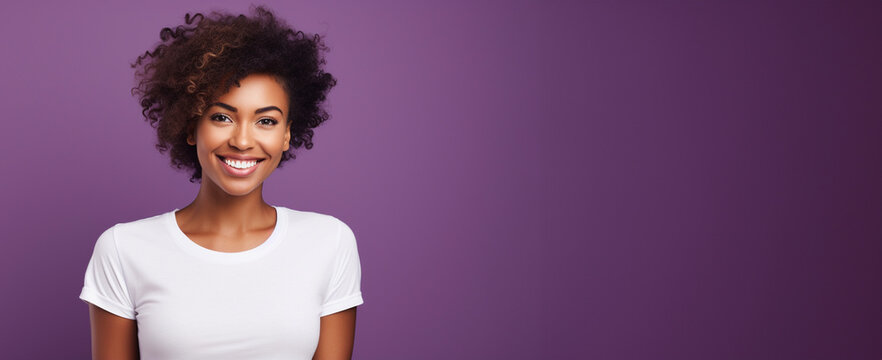 A portrait of a young african american woman with an afro hair style and white t-shirt against a purple background. Feminine, minimalistic style banner with copy space. 