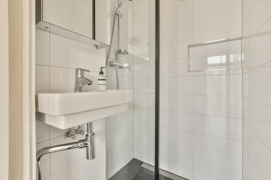 a modern bathroom with white tiles and black grated flooring in the shower stall door is open on the right side