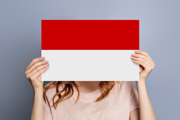 female hands holds blank white speech bubble with Polish flag isolated on grey background