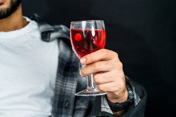 Skillfully arranged, the image captures a man elegantly holding a red colored drink, perfect for advertising