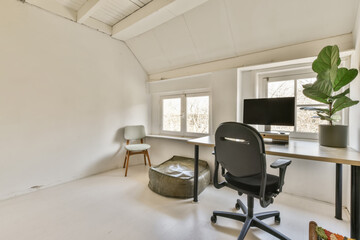a home office space with white walls and wood flooring the room has a computer desk, chair, and window