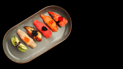 Assorted Nigiri sushi on a plate, on black background