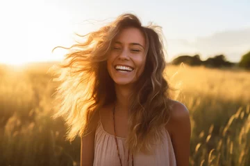 Deurstickers Weide Young happy smiling woman standing in a field with sun shining through her hair