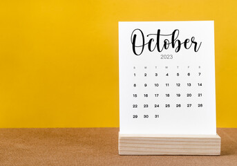 The October 2023 Monthly calendar for 2023 year on yellow table. - obrazy, fototapety, plakaty