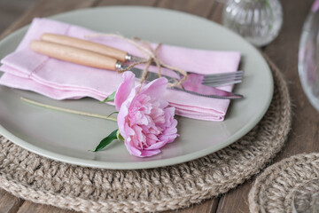 Obraz na płótnie Canvas Table setting with light green ceramic plates and pink peonies