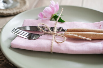 Close-up cutlery. Romantic table setting with pink peonies