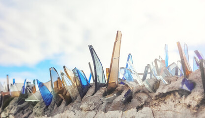 Close up picture of shards of glass on a wall, used to secure private property, selective focus.