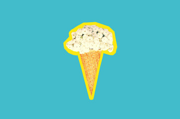 Ice cream cone with flowers on blue background, top view, flat lay, magazine style