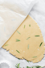 Top view of rolled out rosemary sugar cookie dough, herb cookie dough about to be cut, process of making sugar cookies