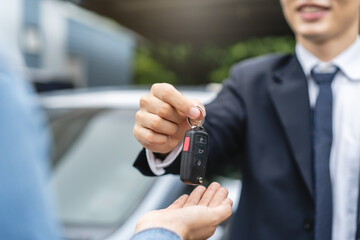transportation rental automotive business concept. Close up hands of rental auto agent giving car...