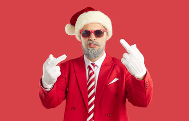 Provocation and rude attitude. Cool cheeky man in Santa hat showing middle finger demonstrating...