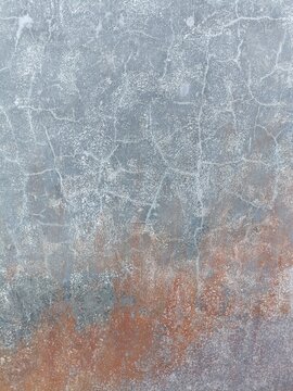 Acid washed concrete floor with random chalky white grid lines and faded red overspray in the lower right corner