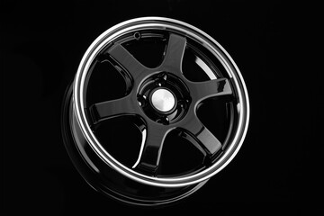 Stylish black die-cast disc for sports design cars on a black background.