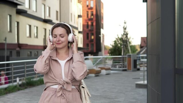 Stylish woman listens to her favorite music track on her way to work, getting ready to start a new day.