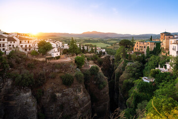 Fototapeta na wymiar El Tajo Canyon at sunrise with Cuenca Gardens, Casa del Rey Moro and Puente Viejo Bridge - Ronda, Andalusia, Spain