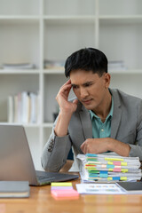 Fototapeta premium tired business man sleepy and bored from sitting at a desk for a long time and has office syndrome