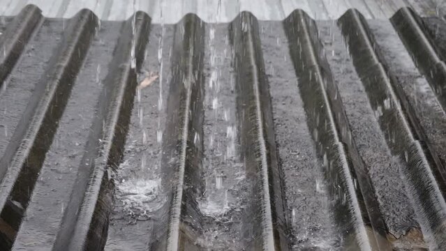 Slow motion of water of rain flowing on the old roo