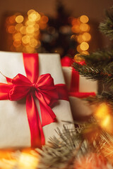 gift in craft paper and red ribbon with bow in lights of christmas