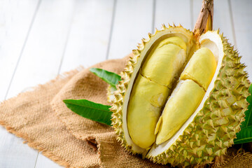 Durian fruit. Ripe monthong durian on sack and white wood background, king of fruit from Thailand