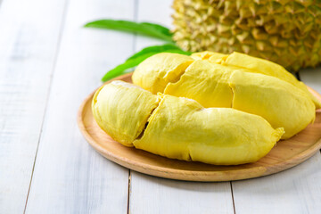 Durian fruit. Ripe monthong durian on wood plate and white wood background, king of fruit from Thailand