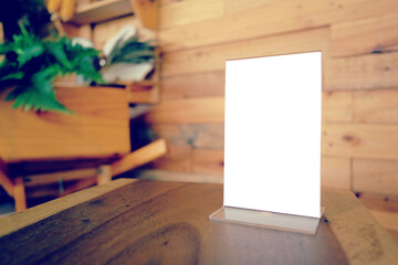 Mock up Menu frame standing on wood table in Bar restaurant cafe. space for text.